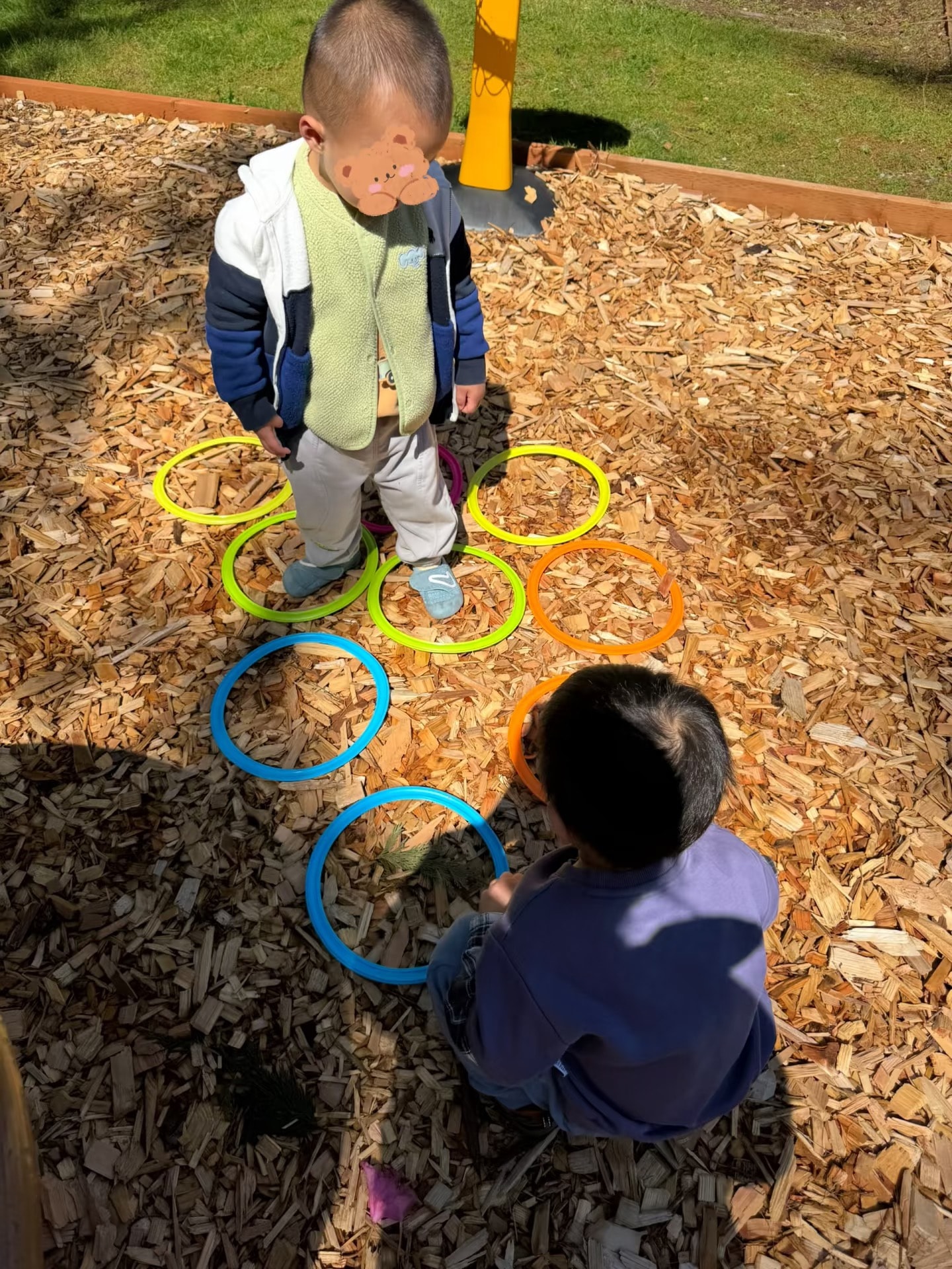 Panda Bear Childcare — toddlers playing hopscotch rings playground